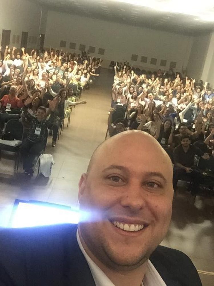 Plateia de fisioterapeutas em teatro durante palestra